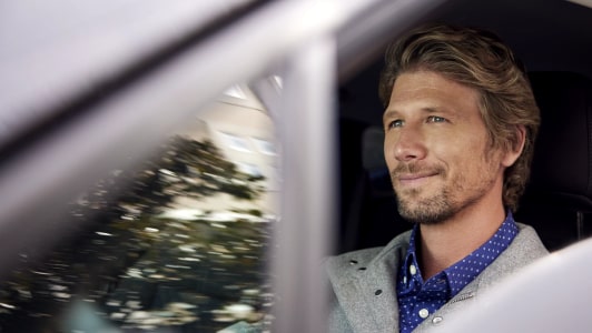 Driver side view of a man driving a vehicle