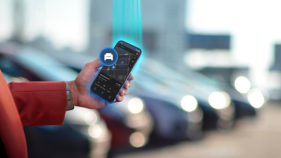 A man holding his phone using the vehicle locator feature.