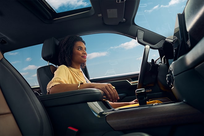 A woman using hands-free driving tech and real-time maps as she drives down the road