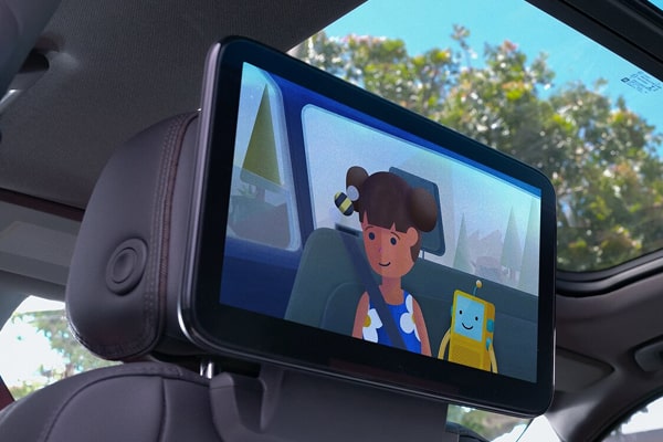 A screen attached to one of the front seat in a vehicle.