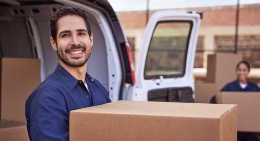 A Smiling Man Carrying a Box 