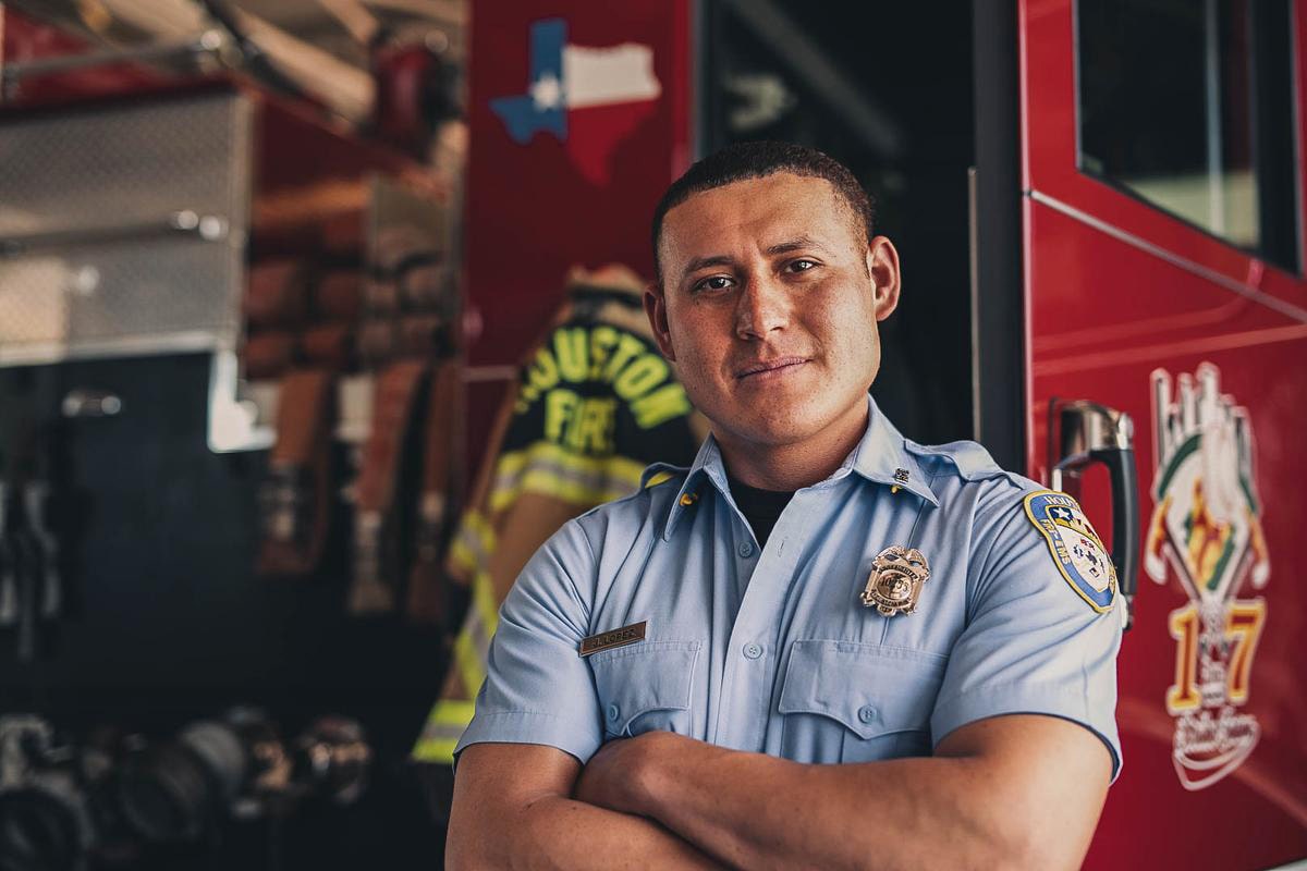 Firefighter Crossed Armed and Smiling in Front of Firetruck