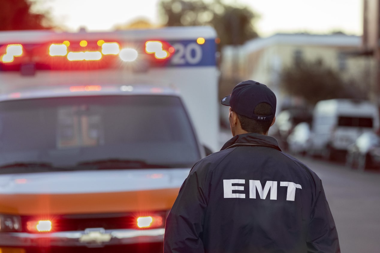 EMT Walking Towards Ambulance With Lights On