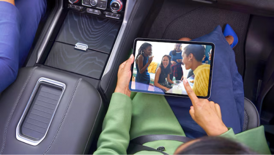 Birds-eye view of a woman using an iPad in the passenger seat