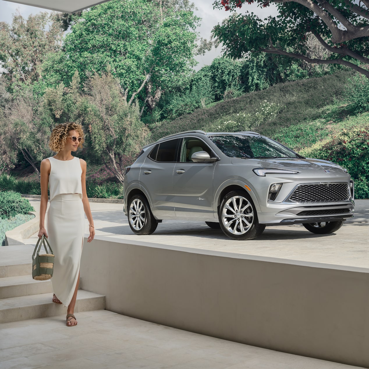 A woman is walking to the right of a parked grey SUV