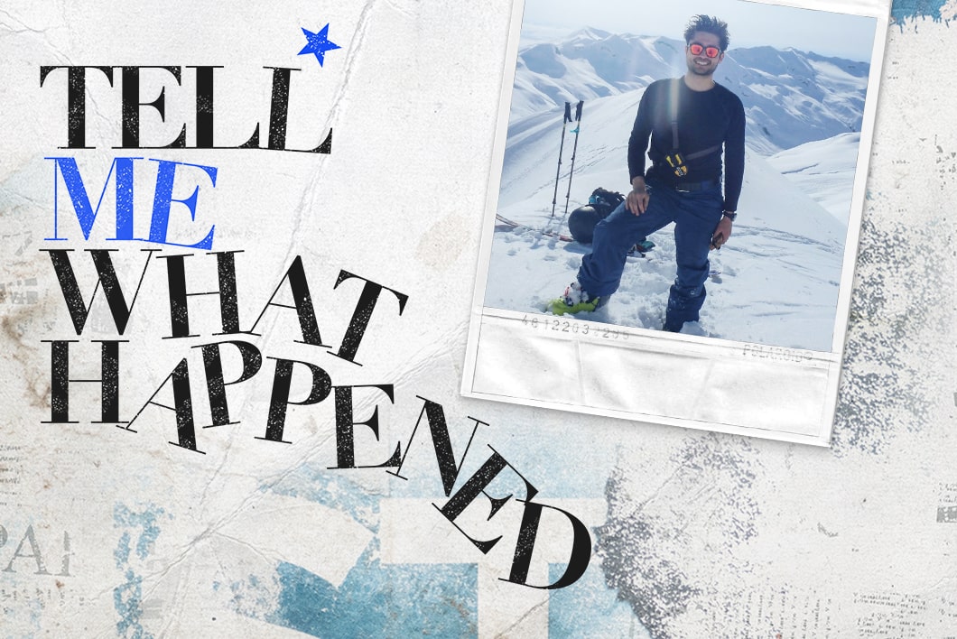 A man wearing sunglasses and traveling gear on top of a snowy mountain next to the text overlay of "Tell Me What Happened".