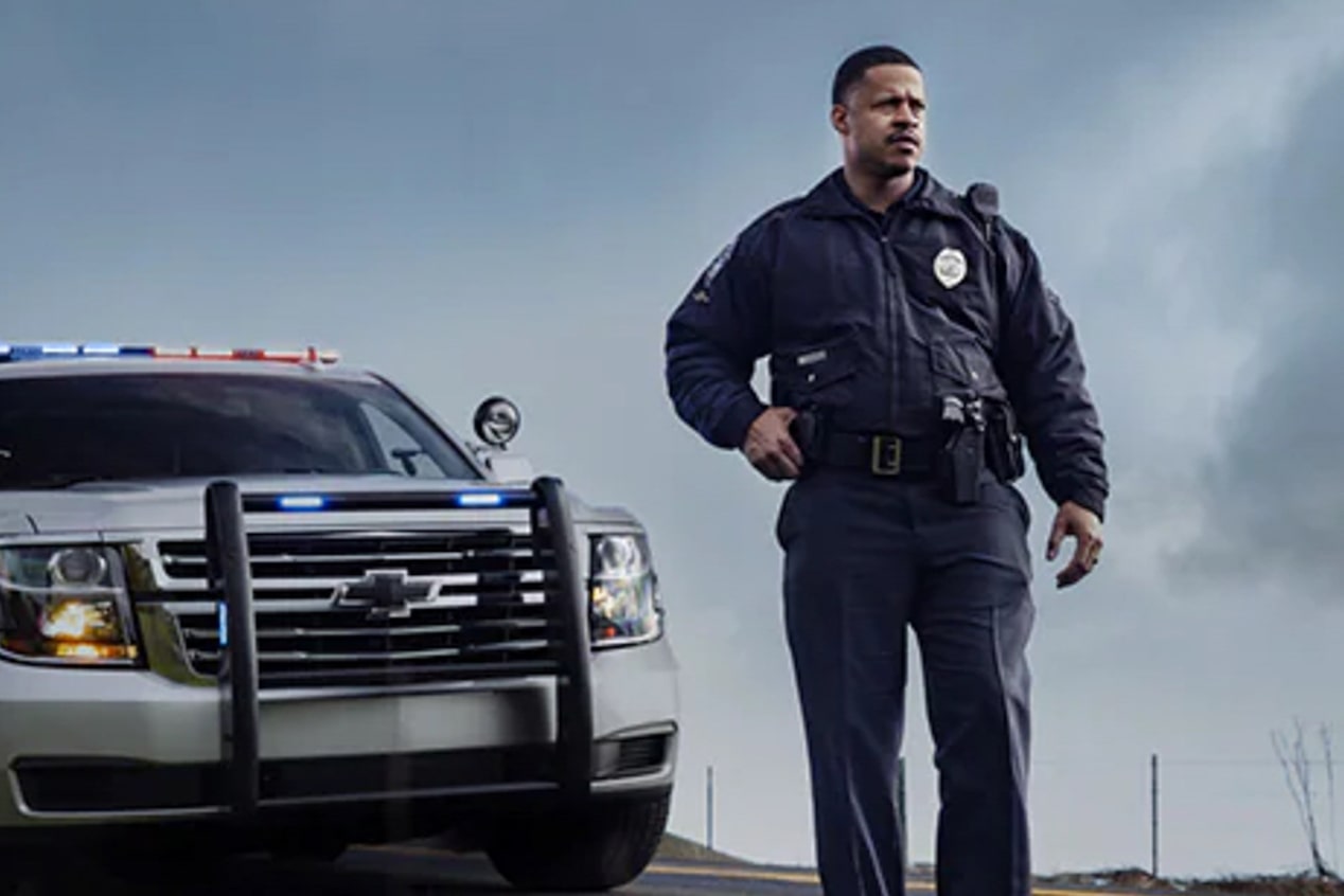 Police Officer Standing in Front of Police Vehicle