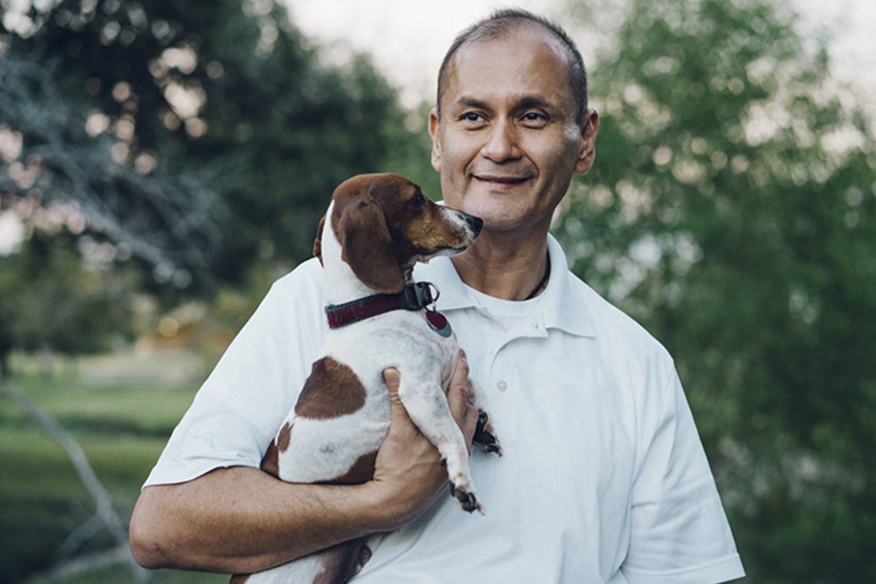 Man Smiling Holding his Dog