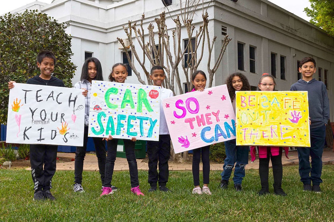 Kids Holding up Colorful Home Made Safetyville Signs