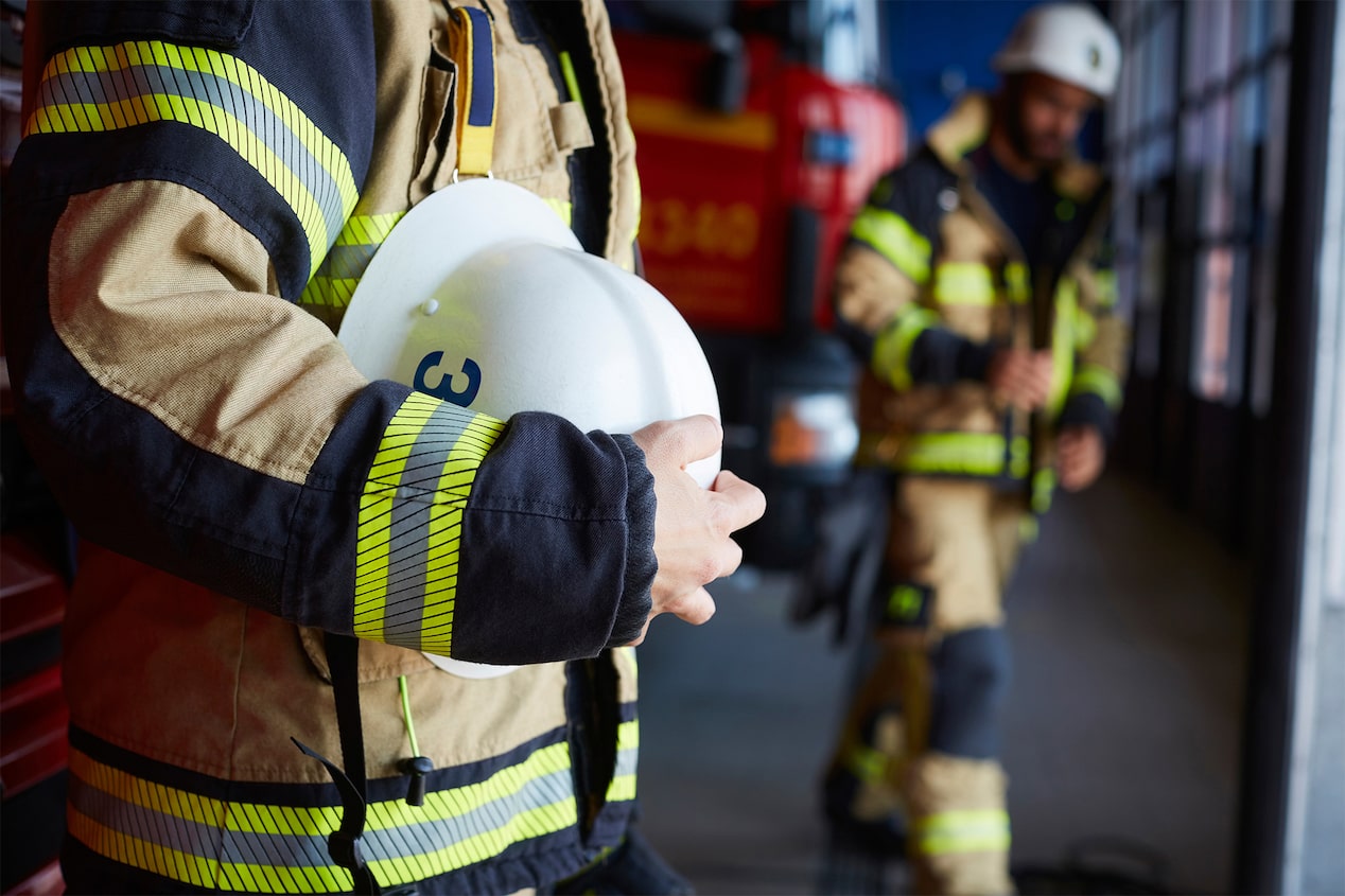 Close-Up of a Firefighter Holding a Helmet and in Gear