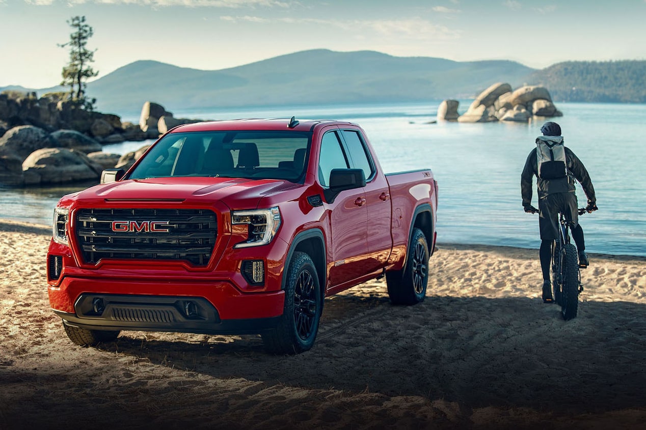 Person Biking on Beach Next to GM Pickup Truck