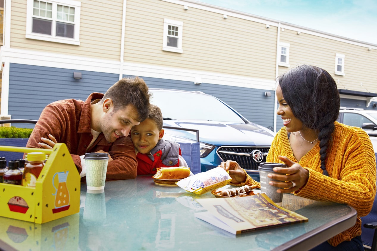 Family Sitting at Rest Stop Together on Road Trip