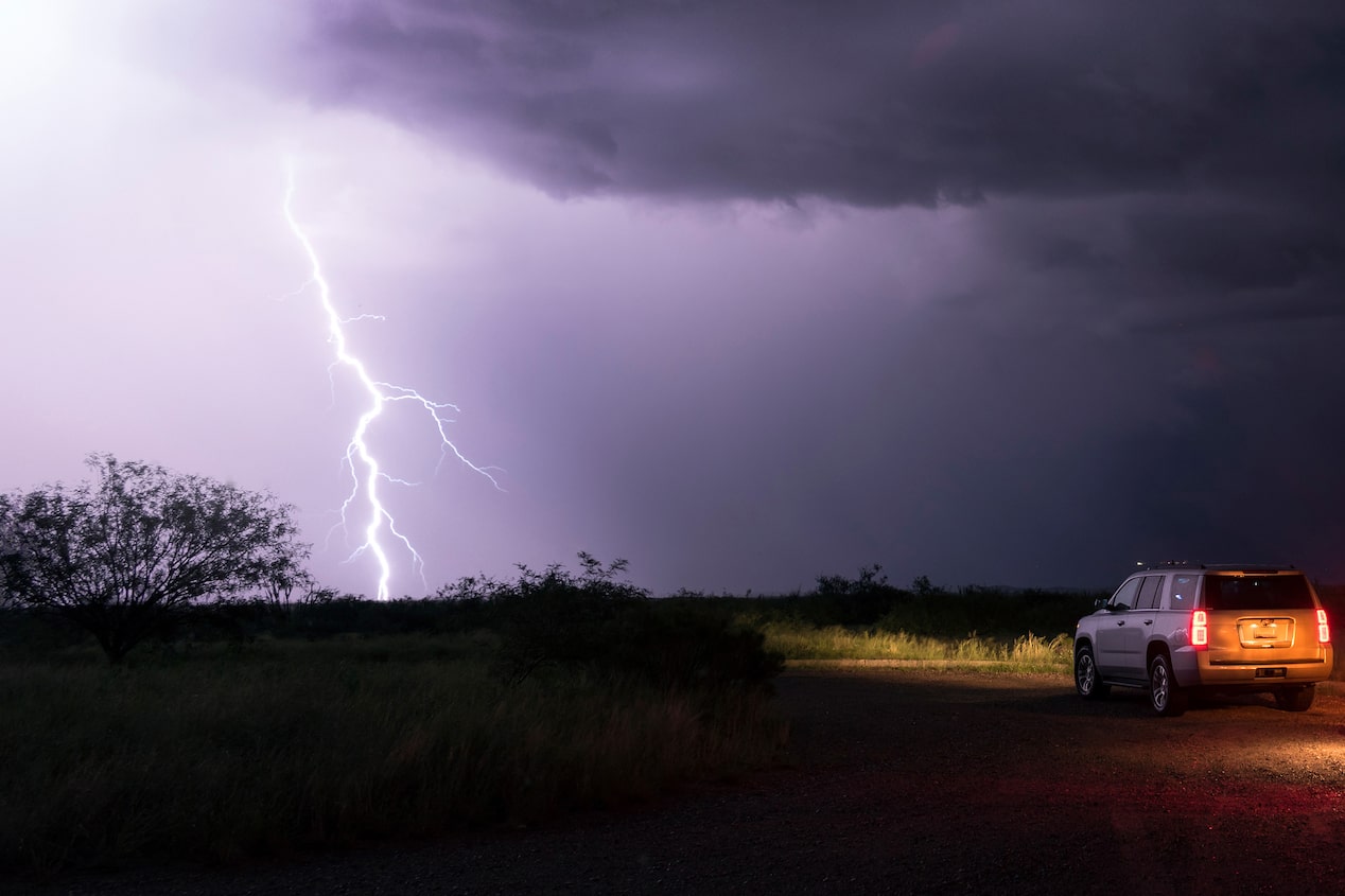 Lightning Strikes in a Bare Field as GM SUV Looks on