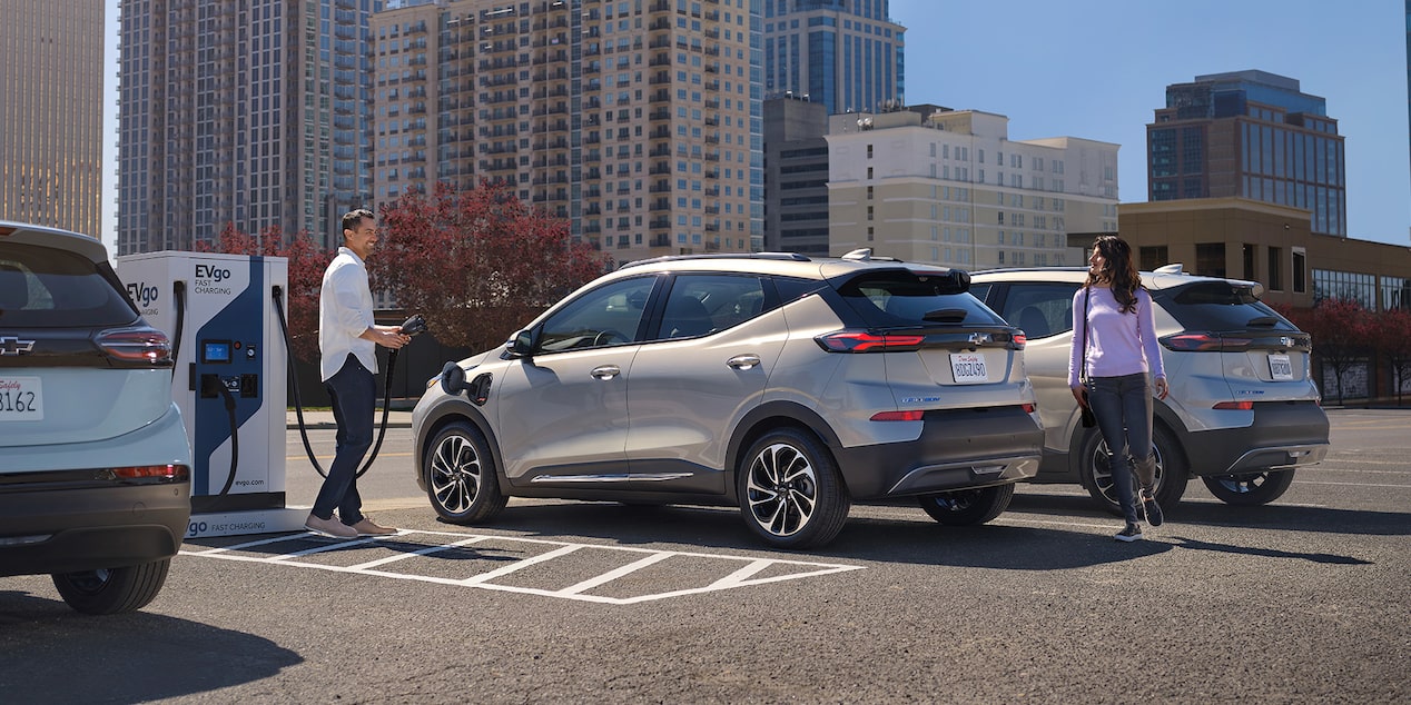 Couple at public charging station charging their electric vehicle 