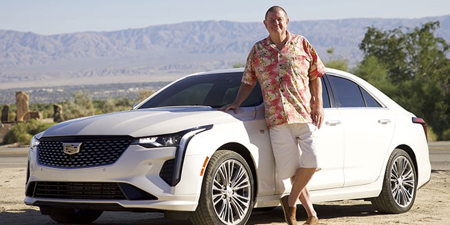 Rusty Austin standing next to his white 2021 Cadillac CT4 