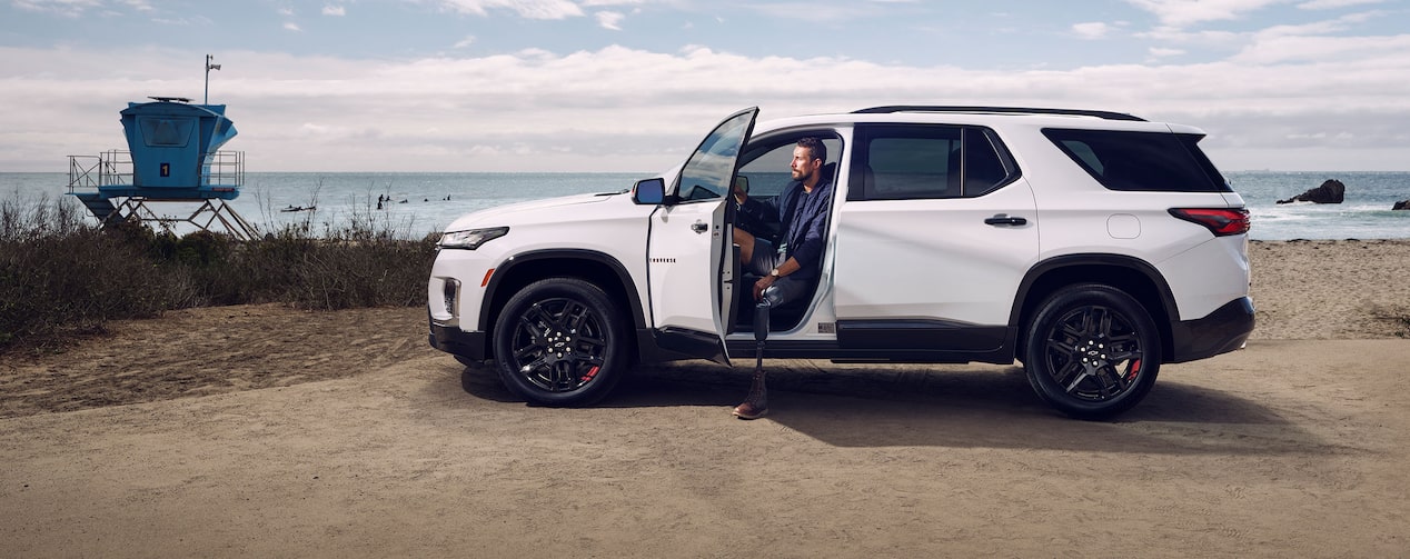 A man with a prosthetic leg stepping out of his GM vehicle at the beach