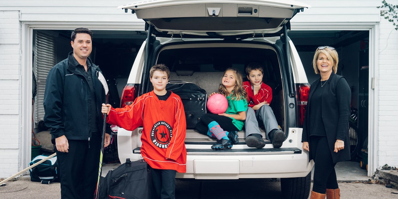 Family of 5 Standing in Drive Way by Open Tailgate