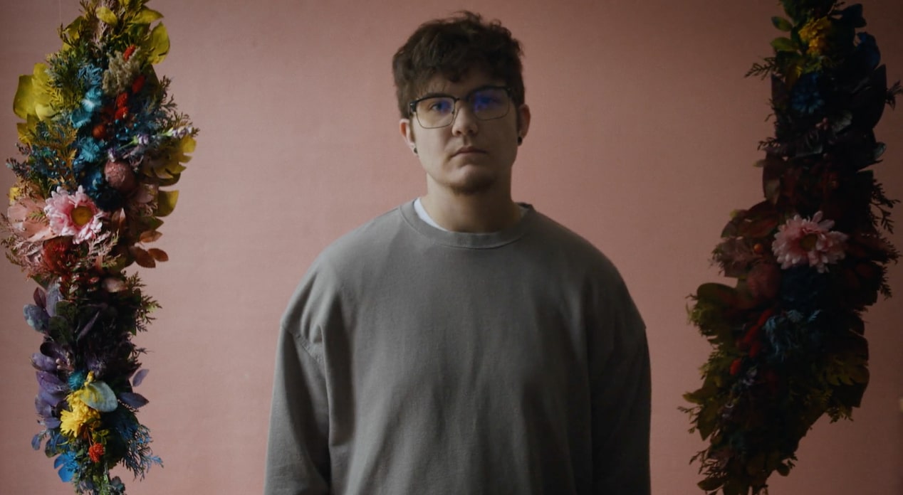 A Man Showing No Emotion in front of a Pink Backdrop