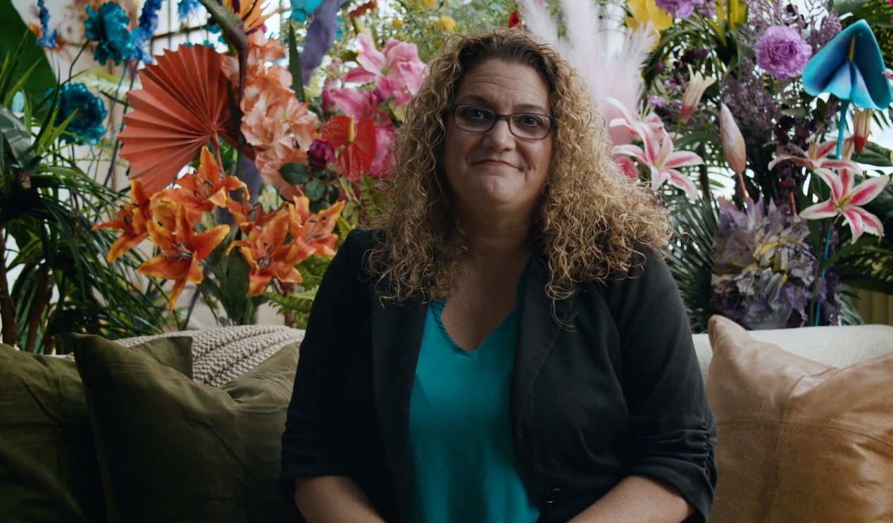 Woman Sitting on a Couch and Smiling at the Camera