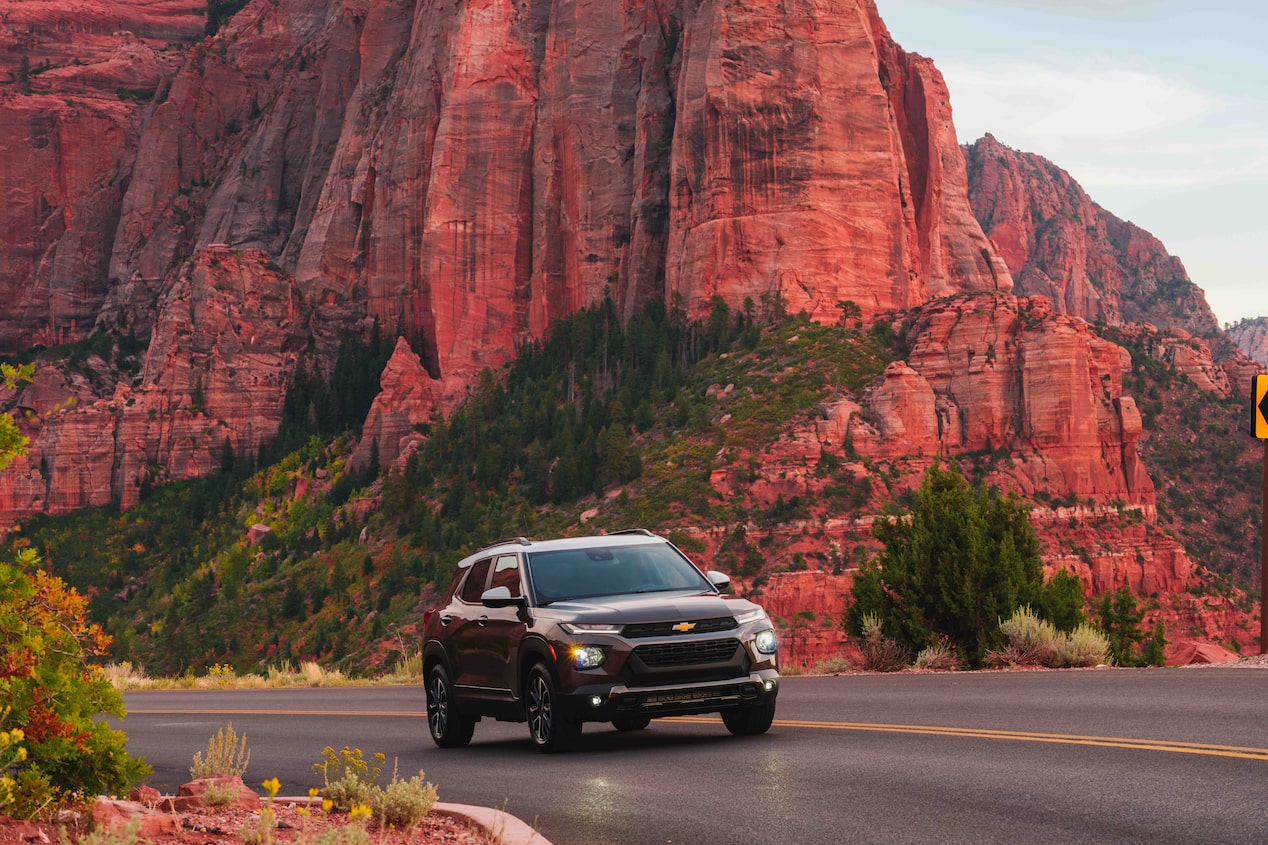 GM Vehicle Driving Down Mountain Lined Road