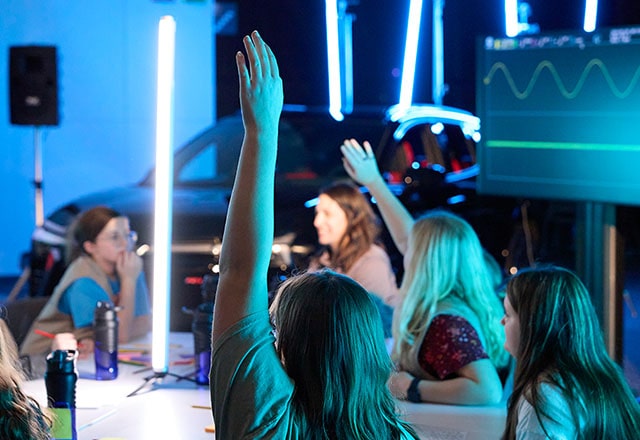 A group of Girl Scouts raising their hands