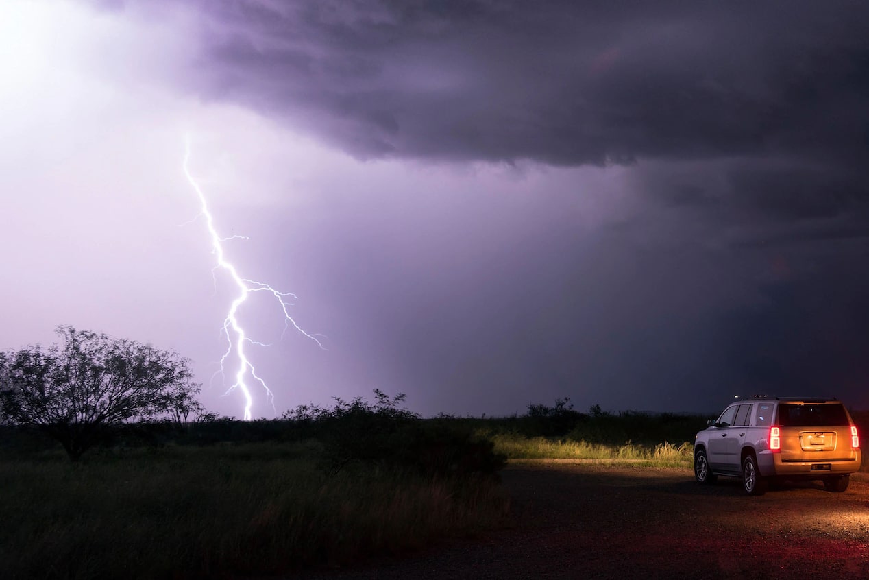 Lightning Bolt in Field with GM SUV