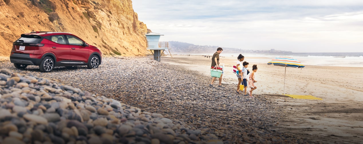 Family Playing on the Beach with Their GM Vehicle Parked in the Background