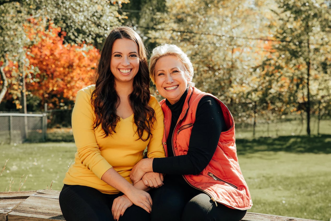 Adult Mother and Daughter Sit Together and Smile