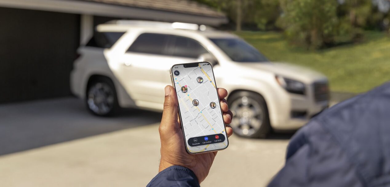 User Looking at the Guardian App With GMC SUV in the Background