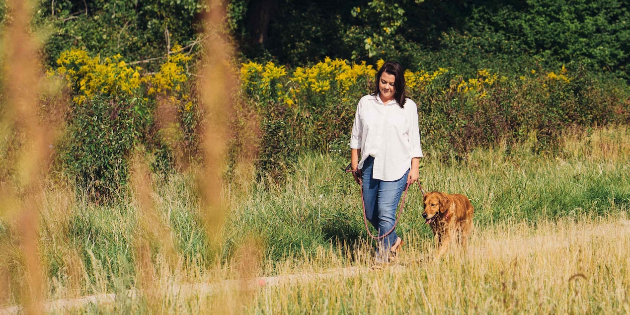 Woman Walking Through Feild with her Dog