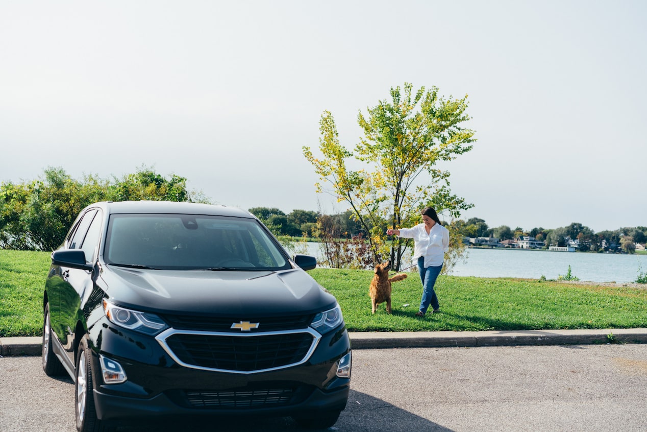 Woman in park playing with her dog near water