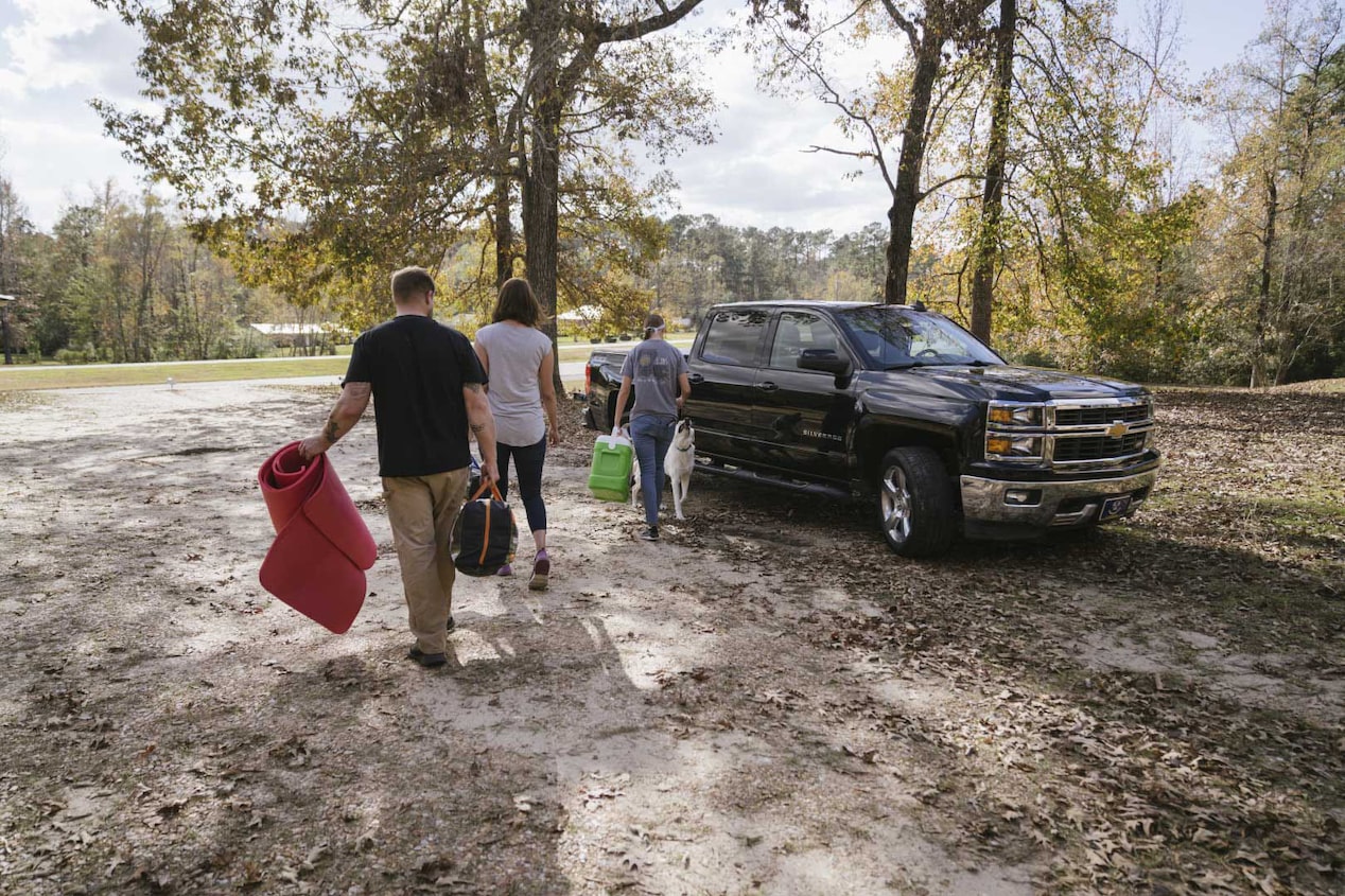 Family Carrying Luggage to Their Chevy Pickup Truck