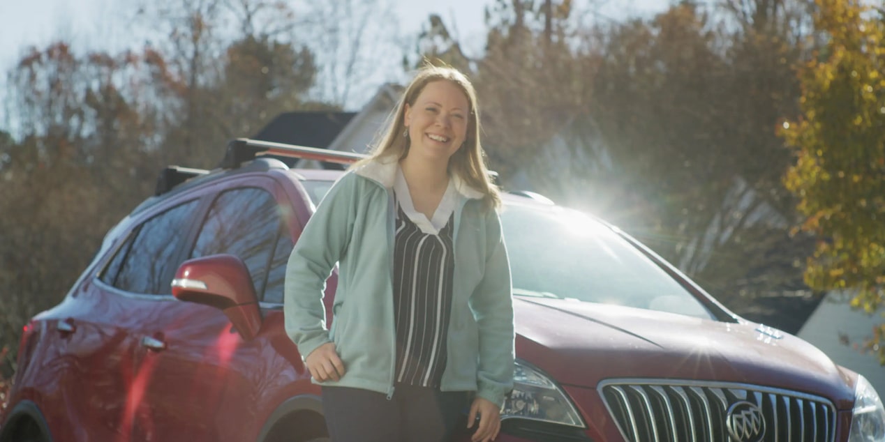 Women Smiling While Leaning on GM Vehicle