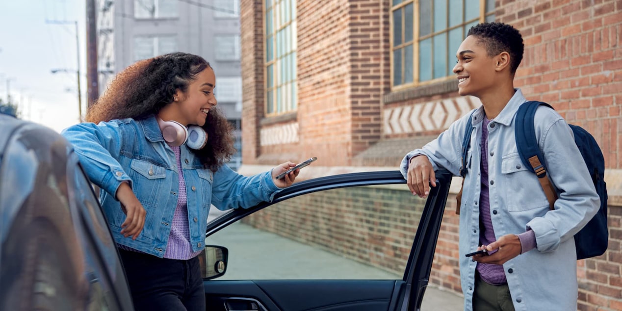 Boy Holding Door While Girl Steps Out of Vehicle