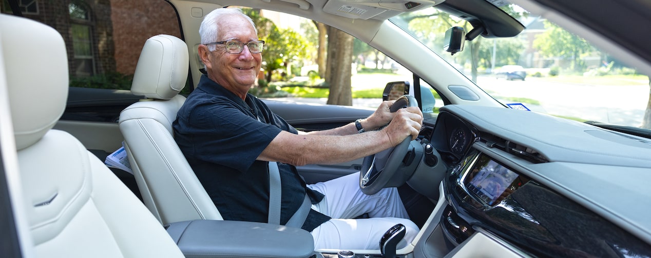 OnStar member Wayne Stoeber smiling while in the driver seat of his GM vehicle