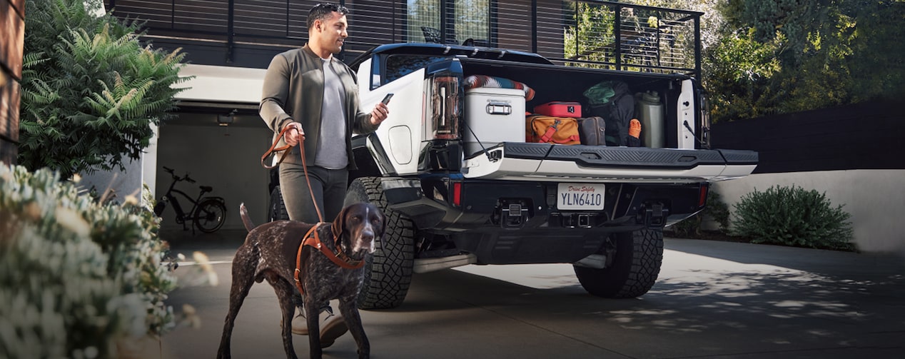 Man With a Dog Loading up the Back of his Pickup Truck