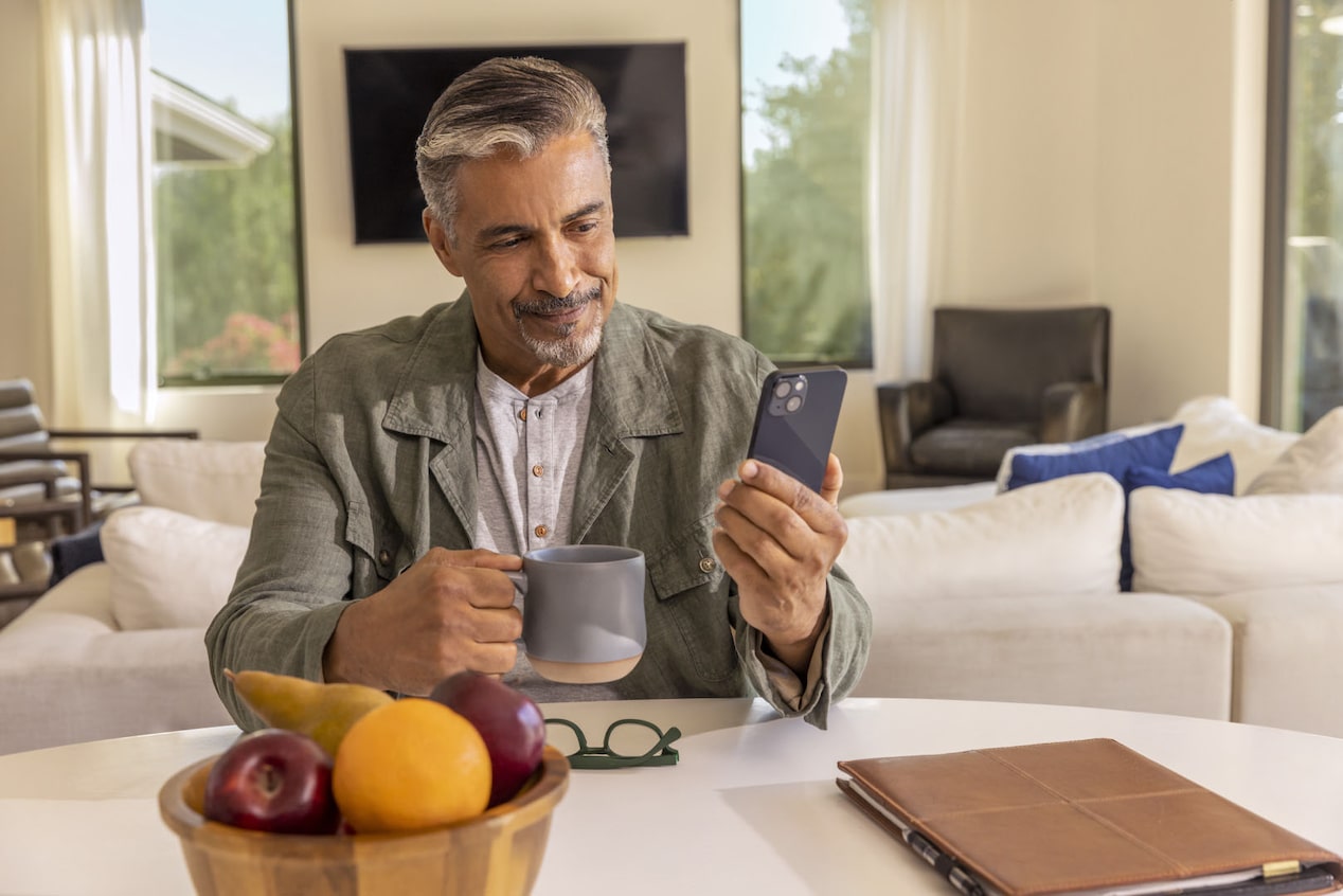 Man Sitting at Table with Coffee and Smartphone