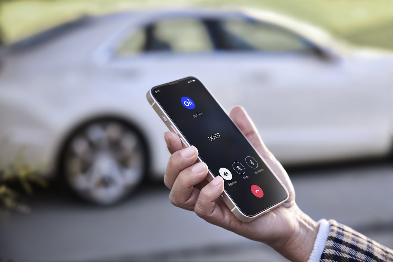 Person on Speaker Phone With OnStar Standing Next to Their Vehicle