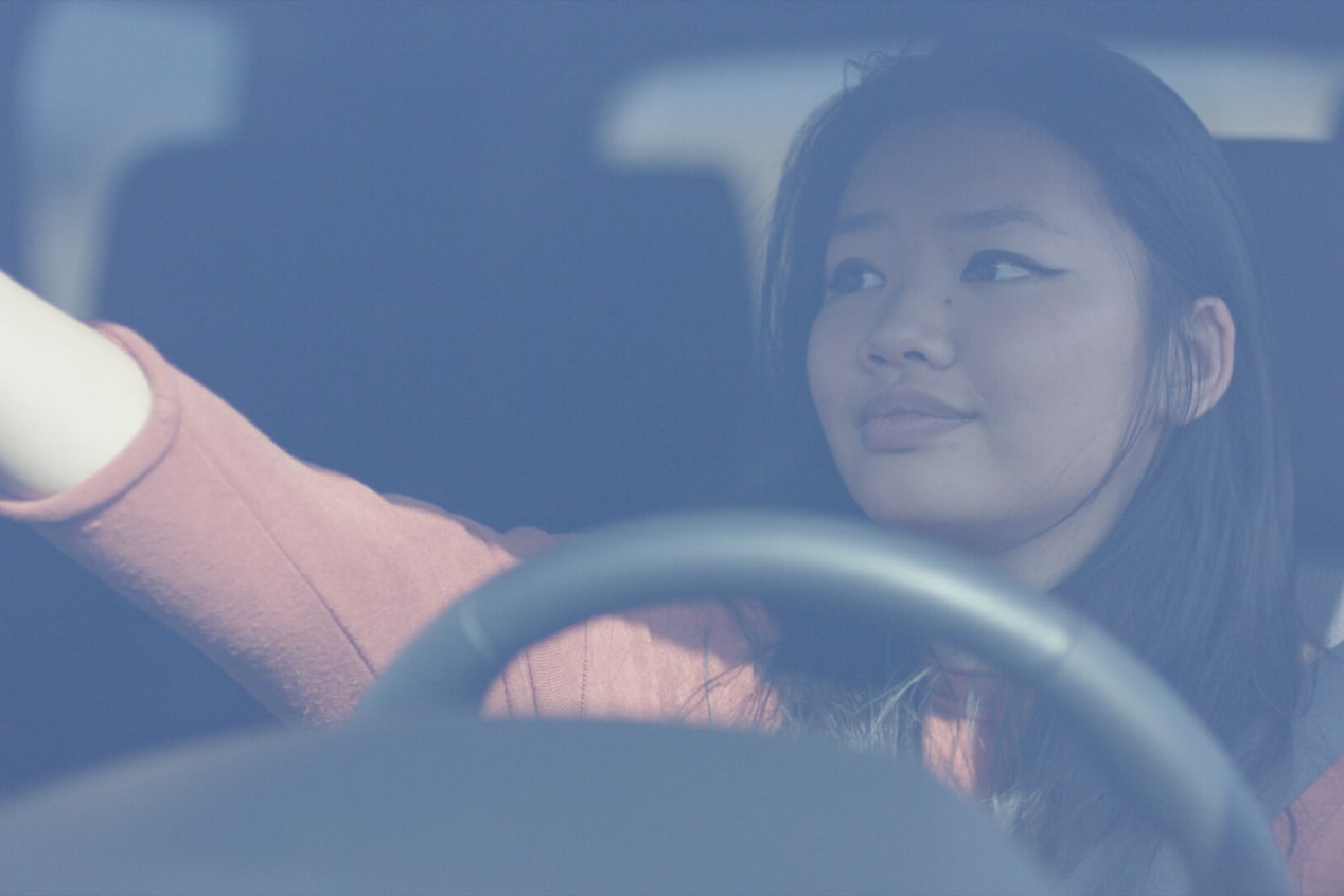 Women Adjusting Vehicles Rear View Mirror