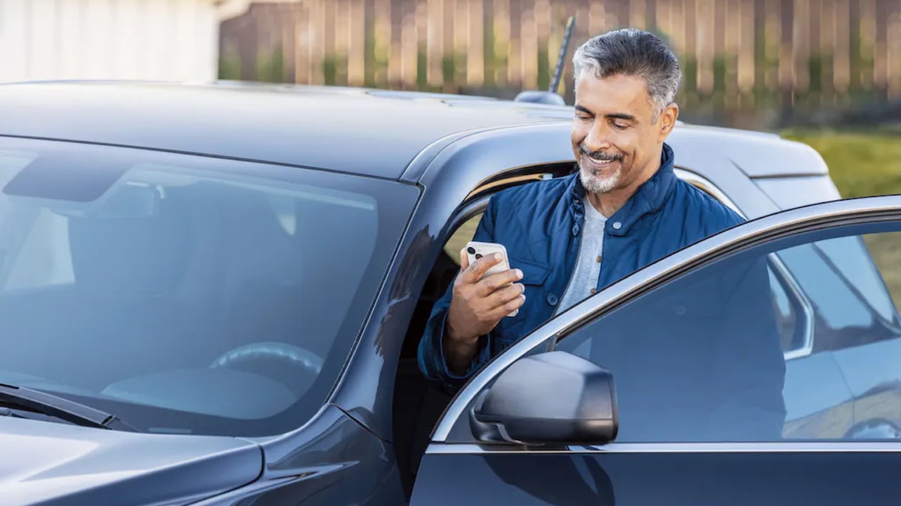 A Man Happily Gets into His Car that was Started Using his Mobile App