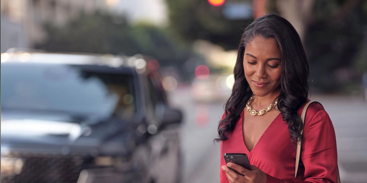 Woman in Red Blouse Checking Her Phone on a City Street