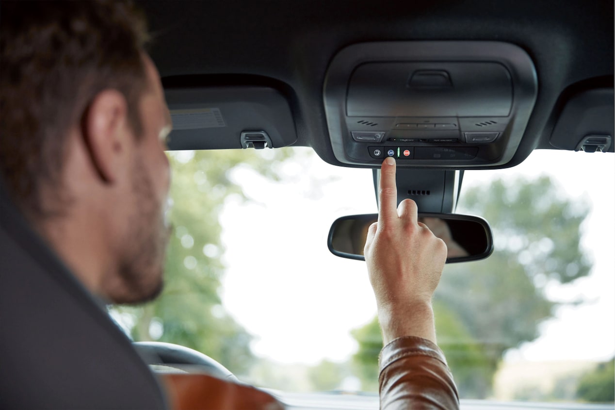 Male Driver Pressing the OnStar Button on His Rearview Mirror