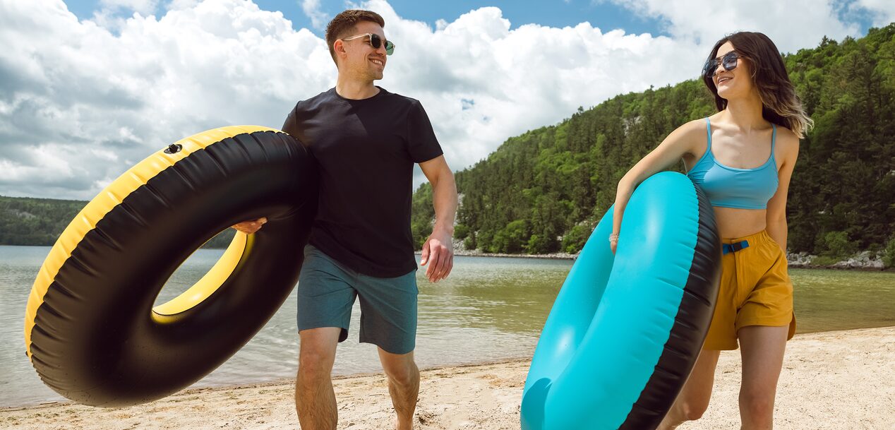 Couple Walking on Beach With Inflatables