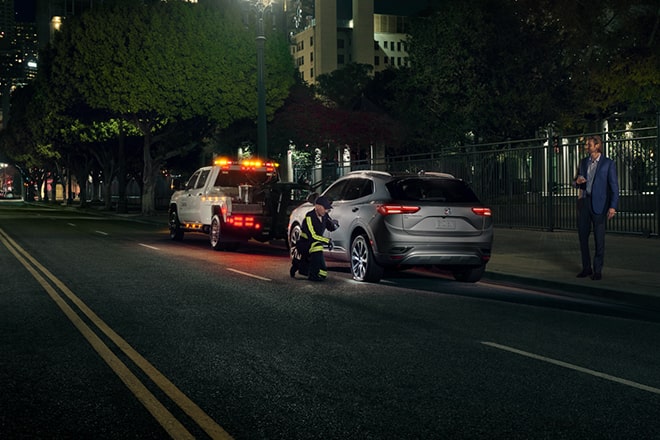 Roadside Assistance Working on a Tire at Night