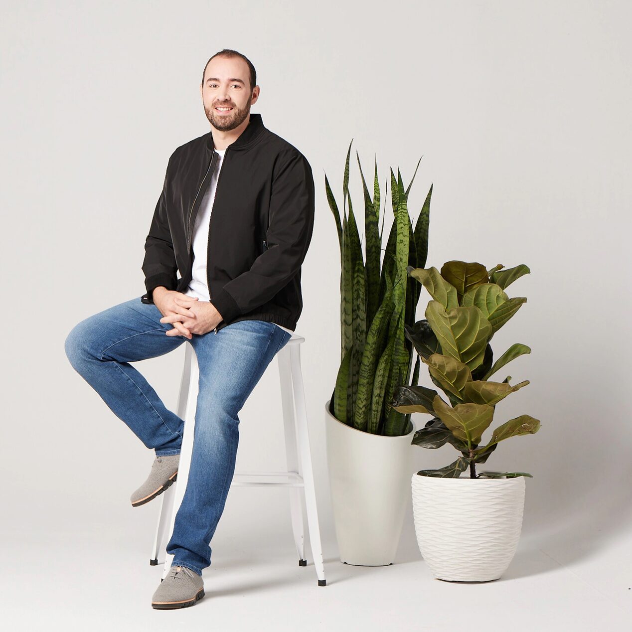 Man Kneeling on a Stool in a Photography Studio